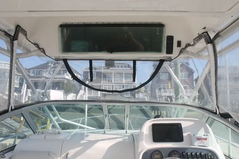 Slide: The Image of 2006 Robalo R265 Walkaround boat interior with dashboard and clear canopy view. - 22