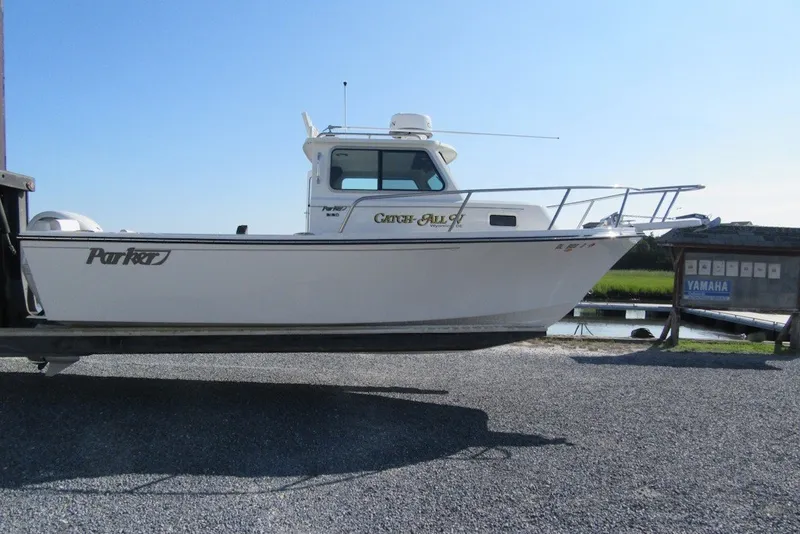 The Image of 2025 Parker 2120 Sport Cabin boat on trailer, side view, clear sky background. - 2