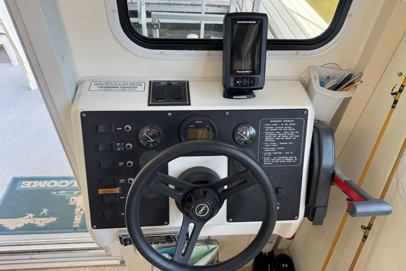Slide: The Image of Helm of 2011 Catamaran Cruisers Lil Hobo 31 with steering wheel and control panel. - 17
