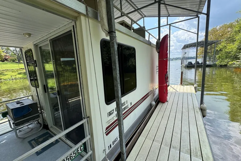 Slide: The Image of 2011 Catamaran Cruisers Lil Hobo 31 houseboat docked by a scenic lakeside. - 7