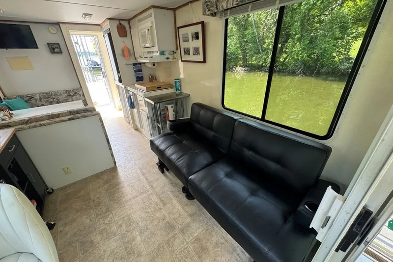 Slide: The Image of Interior of 2011 Catamaran Cruisers Lil Hobo 31 houseboat with sofa and kitchen area. - 14