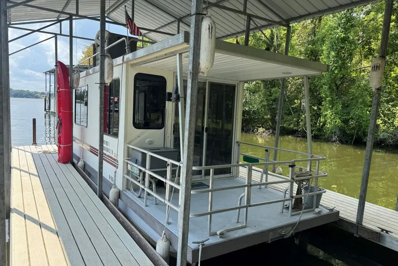 Slide: The Image of 2011 Catamaran Cruisers Lil Hobo 31 houseboat docked on a serene lake. - 4