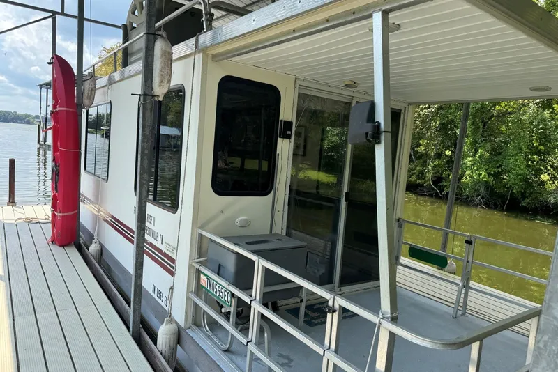 Slide: The Image of 2011 Catamaran Cruisers Lil Hobo 31 houseboat docked by a serene lake. - 5