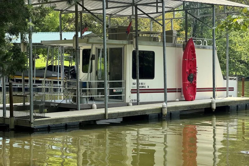 The Image of 2011 Catamaran Cruisers Lil Hobo 31 houseboat docked with red kayak attached. - 1