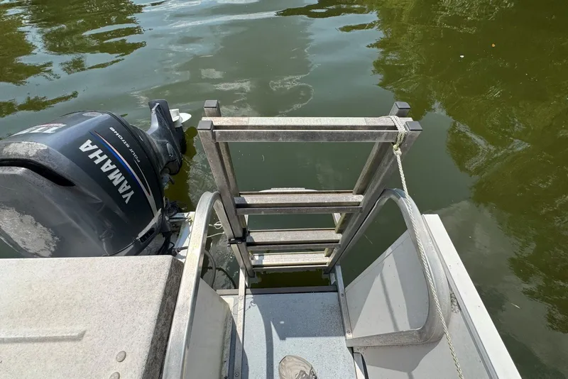 Slide: The Image of 2011 Catamaran Cruisers Lil Hobo 31 with Yamaha motor and swim ladder on calm water. - 35