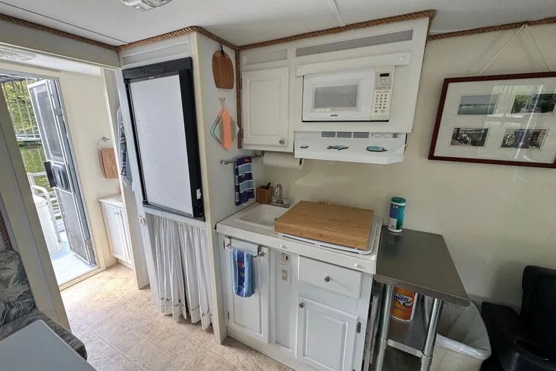Slide: The Image of Compact kitchen area in a 2011 Catamaran Cruisers Lil Hobo 31 houseboat. - 26