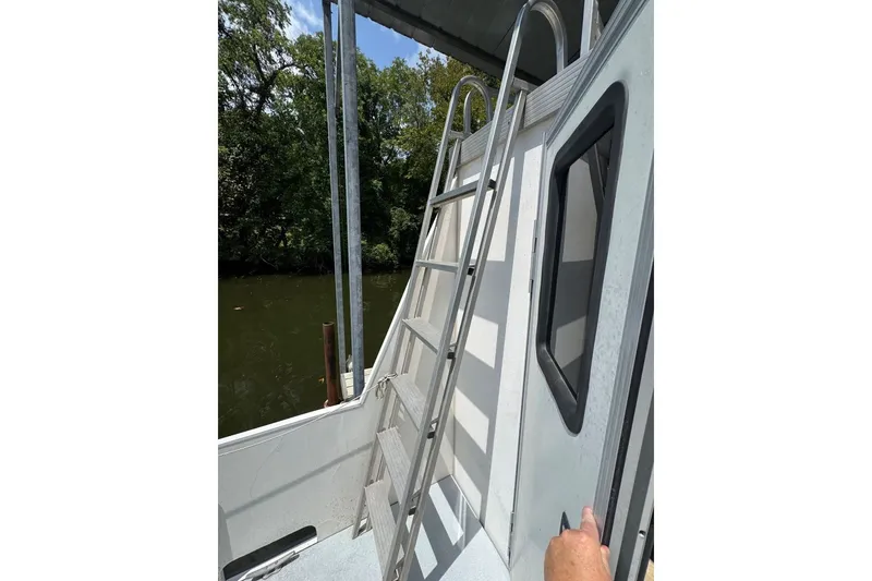 Slide: The Image of 2011 Catamaran Cruisers Lil Hobo 31 with ladder and window, docked by a river. - 39