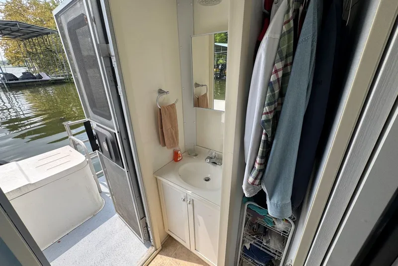 Slide: The Image of Interior of 2011 Catamaran Cruisers Lil Hobo 31, featuring a compact bathroom and closet. - 31