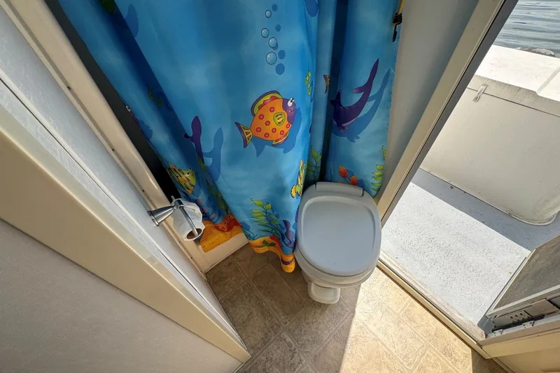 Slide: The Image of Bathroom in 2011 Catamaran Cruisers Lil Hobo 31 with colorful fish-themed shower curtain. - 32