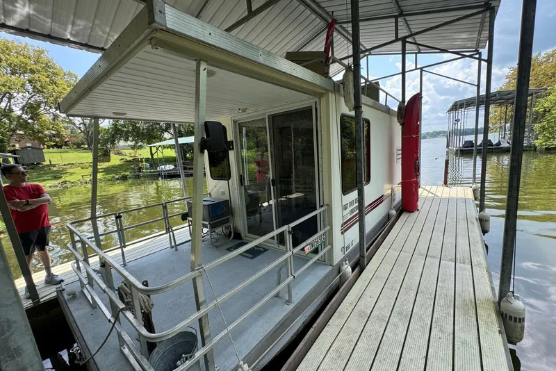 Slide: The Image of 2011 Catamaran Cruisers Lil Hobo 31 houseboat docked by a scenic lakeside. - 6
