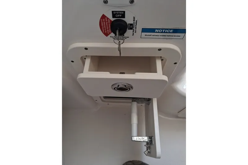 Slide: The Image of Century 3200 Center Console 2020 boat compartment with key lock and notice label. - 12