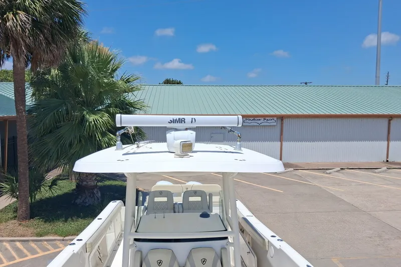 Slide: The Image of Century 3200 Center Console 2020 boat with T-top, parked near palm trees and building. - 9