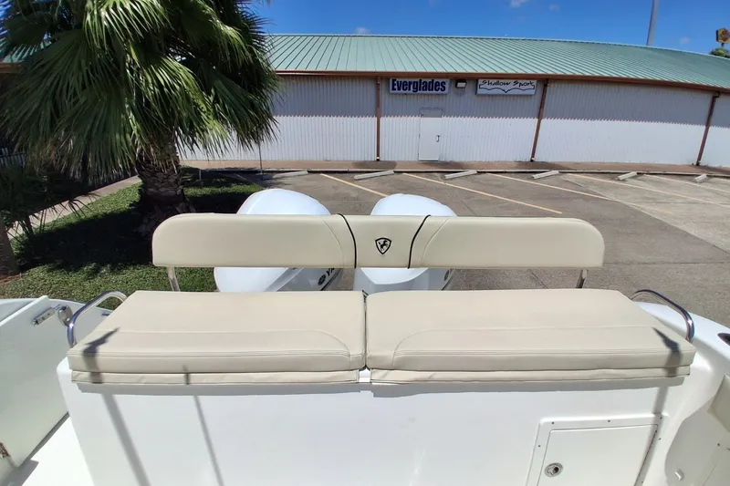 Slide: The Image of Century 3200 Center Console 2020 boat with beige seating, parked near a building. - 29