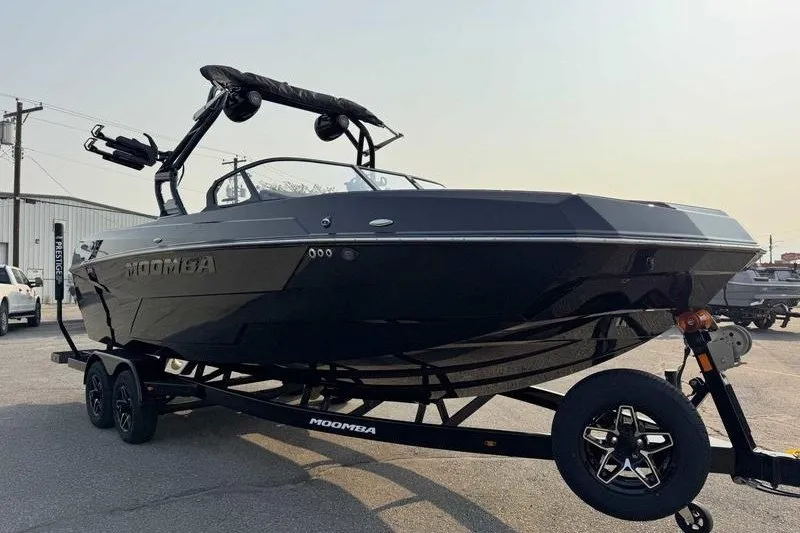 Slide: The Image of 2027 Moomba Tykon boat on trailer, sleek black design, parked outdoors. - 15