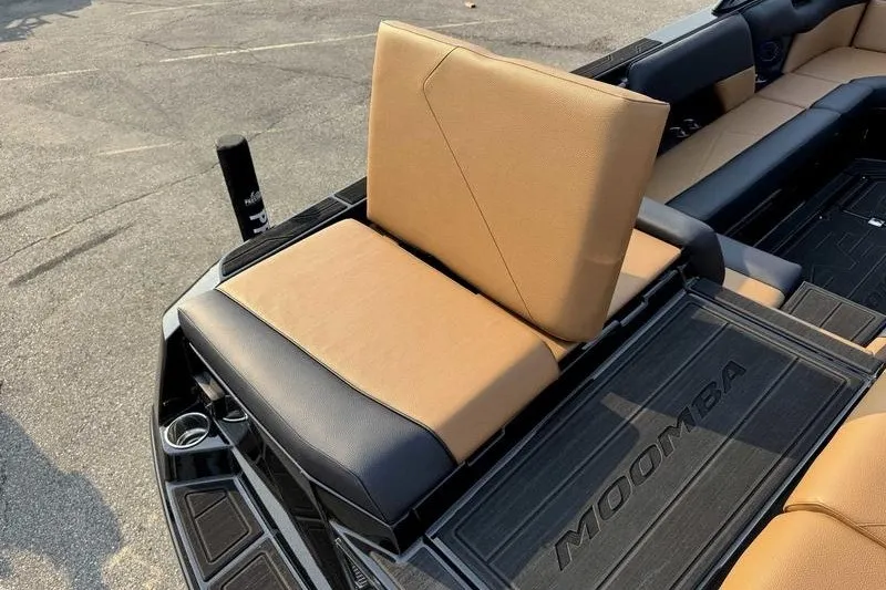 Slide: The Image of 2027 Moomba Tykon boat interior with tan and black seating, showcasing luxury design. - 2