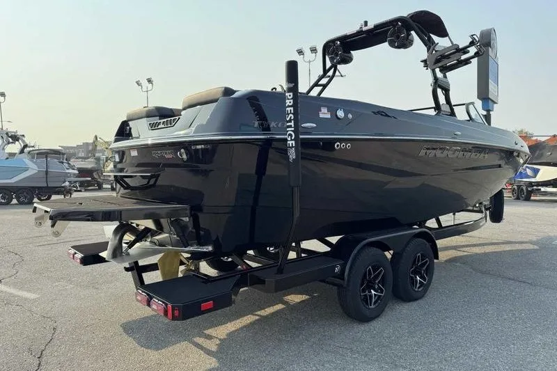 Slide: The Image of 2027 Moomba Tykon boat on trailer, sleek black design, parked outdoors. - 4