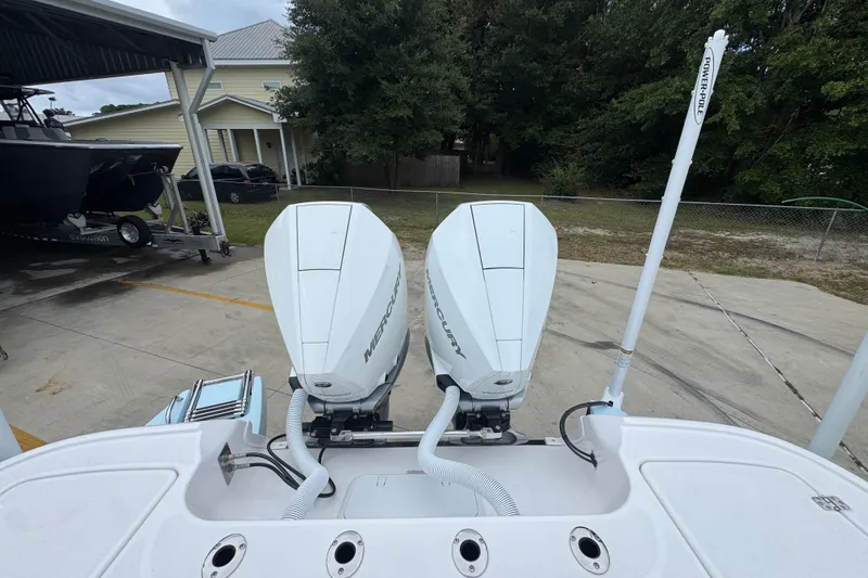 Slide: The Image of 2027 Caymas 281 HB boat with dual Mercury outboard engines in a driveway. - 48