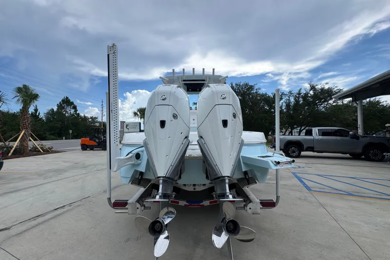 Slide: The Image of 2027 Caymas 281 HB boat with dual outboard motors in a parking lot. - 16