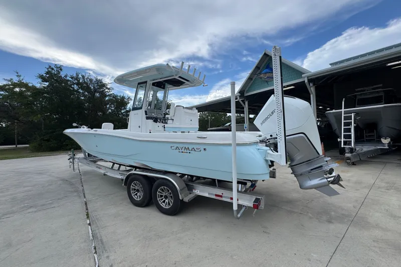 Slide: The Image of 2027 Caymas 281 HB boat on trailer, parked outdoors near a building. - 19