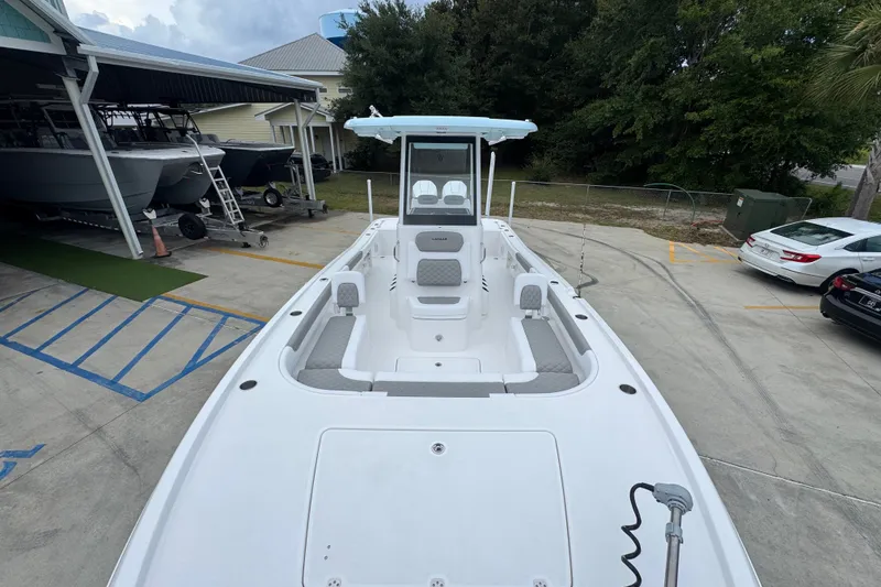Slide: The Image of 2027 Caymas 281 HB boat in a parking area, showcasing spacious deck and seating. - 26