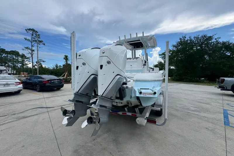 Slide: The Image of 2027 Caymas 281 HB boat with dual outboard motors on a trailer in a parking lot. - 15