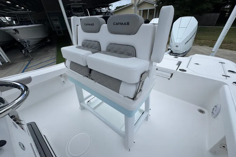 Slide: The Image of 2027 Caymas 281 HB boat with cushioned seating and modern design in a showroom. - 31