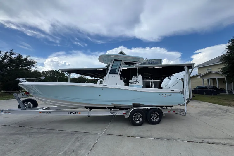 The Image of 2027 Caymas 281 HB boat on trailer, parked outdoors under a cloudy sky. - 1