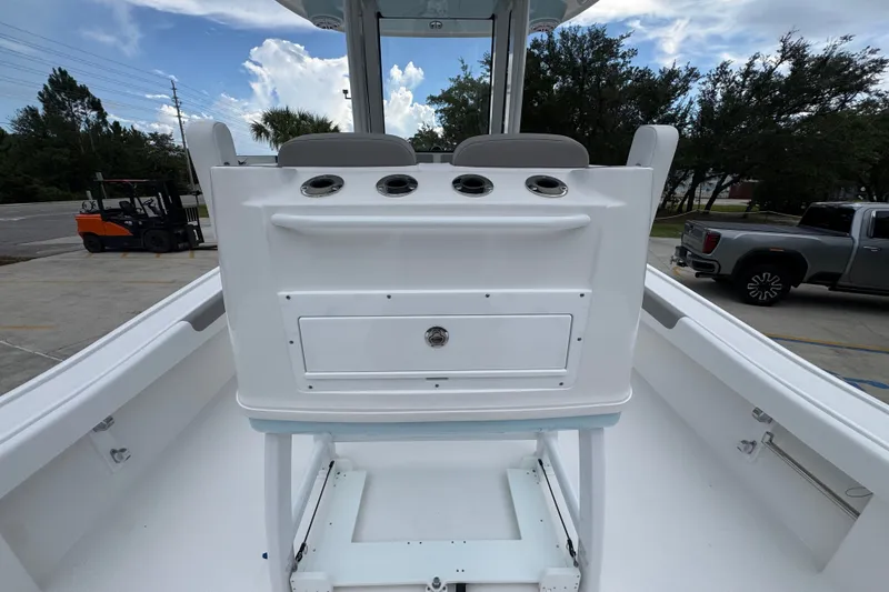 Slide: The Image of 2027 Caymas 281 HB boat interior with seating and storage, parked outdoors. - 42