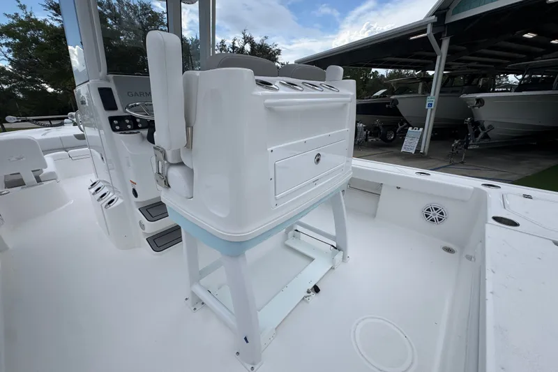 Slide: The Image of 2027 Caymas 281 HB boat interior with console and seating, docked near other boats. - 40