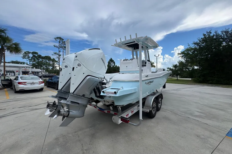 Slide: The Image of 2027 Caymas 281 HB boat on trailer with dual outboard motors in parking lot. - 14
