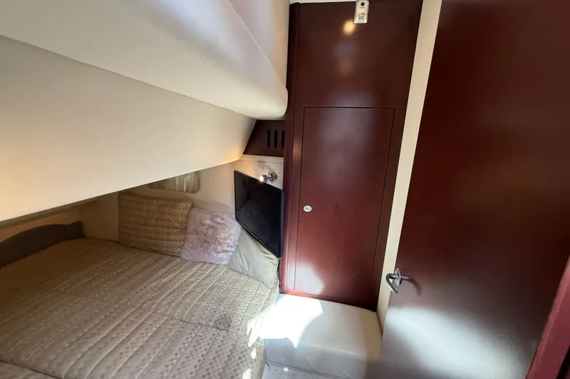 Slide: The Image of 2008 Sea Ray 44 Sedan Bridge cabin interior with cozy bed and wooden cabinetry. - 48