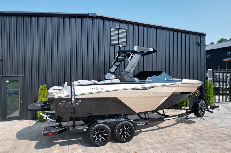 Slide: The Image of 2027 Tige Z1 boat on trailer, parked outside a modern building. - 25