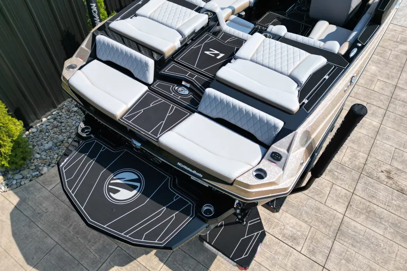 Slide: The Image of 2027 Tige Z1 boat with luxurious seating and sleek design on a wooden dock. - 13