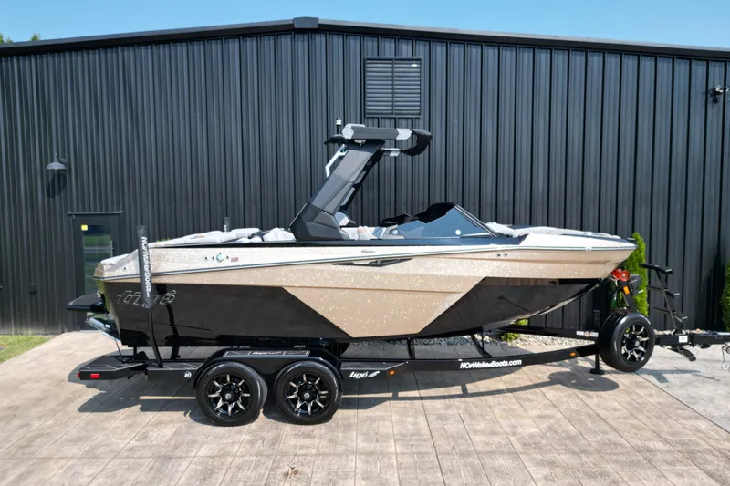 Slide: The Image of 2027 Tige Z1 boat on trailer, parked outside a black building. - 3