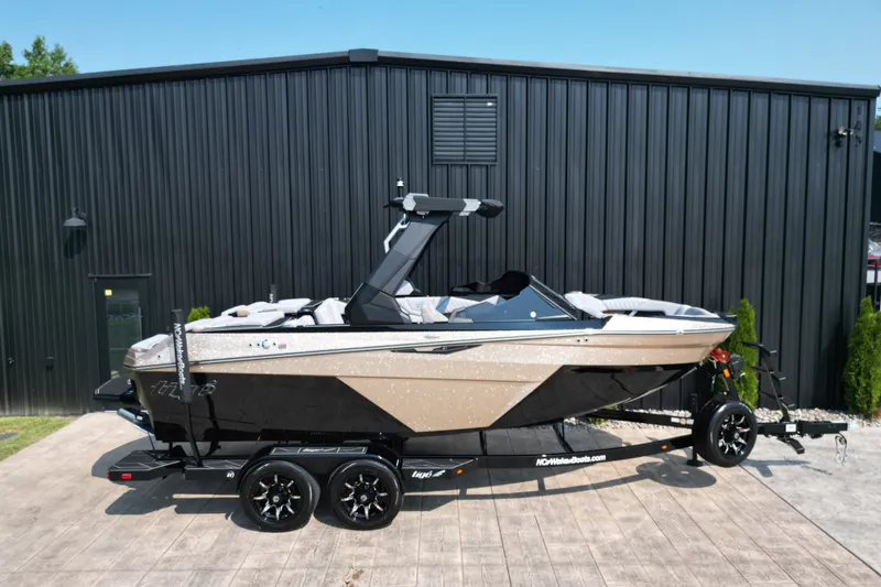 Slide: The Image of 2027 Tige Z1 boat on trailer, parked outside a black building. - 22