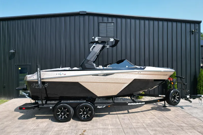 Slide: The Image of 2027 Tige Z1 boat on trailer, parked outside a black building. - 26