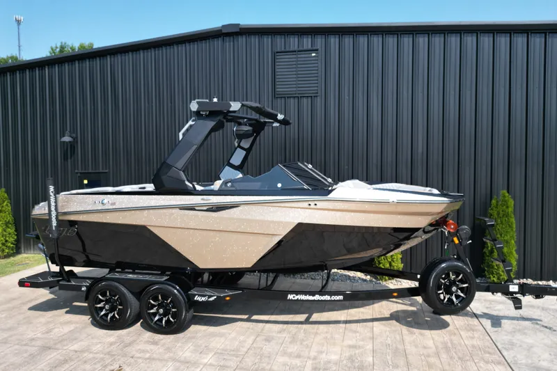 Slide: The Image of 2027 Tige Z1 boat on trailer, parked outdoors near a black building. - 4
