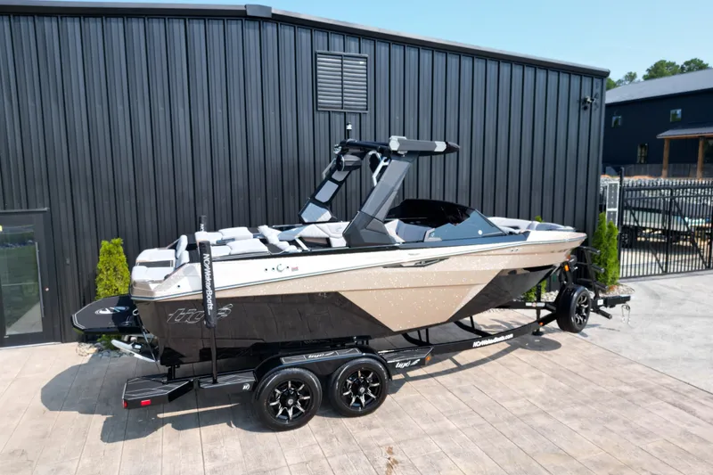 Slide: The Image of 2027 Tige Z1 boat on trailer, parked outside a modern building. - 21