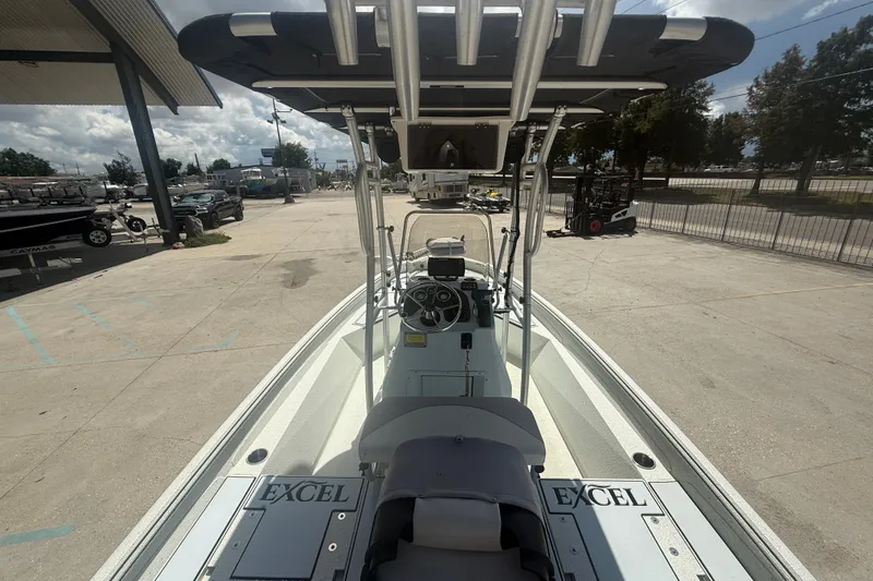 Slide: The Image of 2021 Excel 203 Bay Pro boat with T-top and console, parked outdoors. - 7