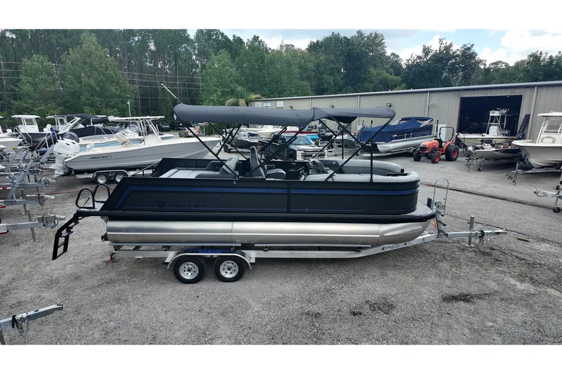 Slide: The Image of 2027 Viaggio X22S pontoon boat on trailer, parked in a marina lot. - 1