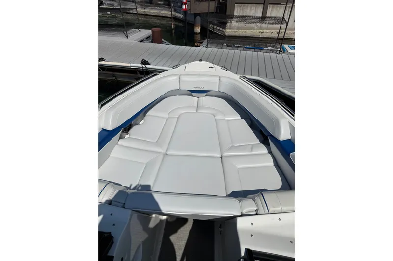 Slide: The Image of 2022 Formula 270 Bowrider boat with spacious white seating at the dock. - 13