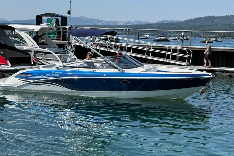 The Image of 2022 Formula 270 Bowrider boat docked on a sunny lake with scenic mountain views. - 0
