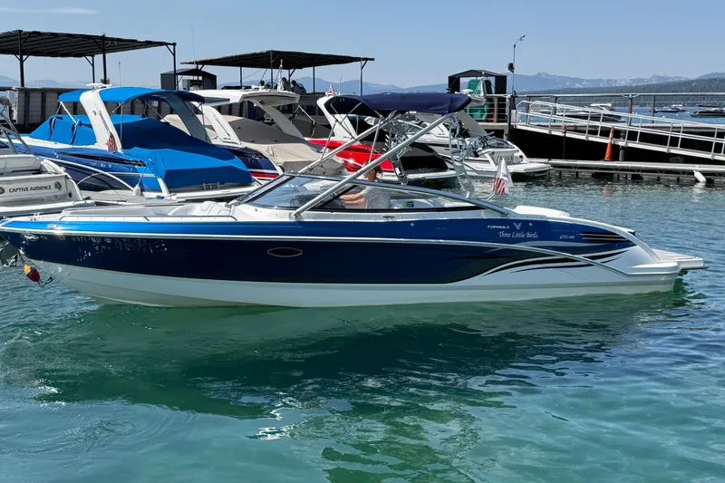 Slide: The Image of 2022 Formula 270 Bowrider boat docked in a marina with clear blue water. - 1