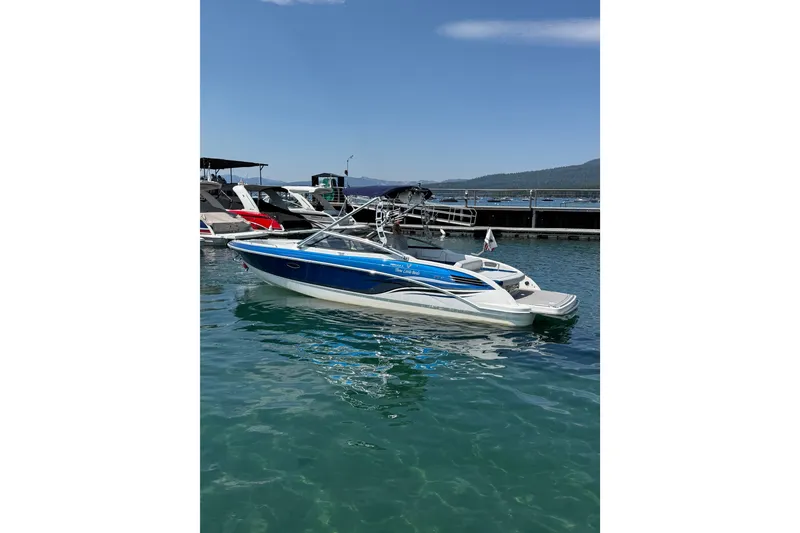 Slide: The Image of 2022 Formula 270 Bowrider boat docked on clear water under a blue sky. - 6
