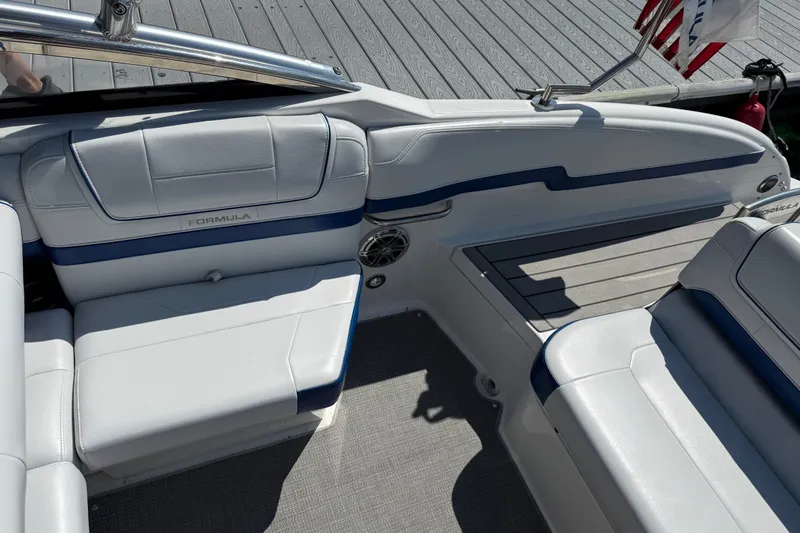 Slide: The Image of 2022 Formula 270 Bowrider interior with white and blue seating, docked by a wooden pier. - 15