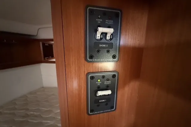 Slide: The Image of Electrical panel on 2008 Beneteau Oceanis 46 yacht, featuring shore power switches. - 49