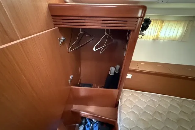 Slide: The Image of Wooden closet interior on 2008 Beneteau Oceanis 46 yacht, featuring hangers and storage space. - 59