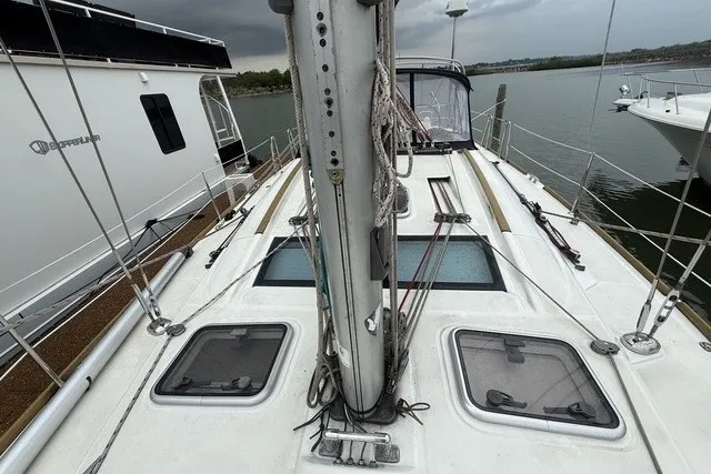 Slide: The Image of 2008 Beneteau Oceanis 46 sailboat deck with mast and hatches, docked by the water. - 6