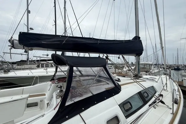 Slide: The Image of 2008 Beneteau Oceanis 46 sailboat docked at marina, featuring sleek design and covered sails. - 3
