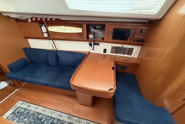 Slide: The Image of Interior of 2008 Beneteau Oceanis 46 yacht with wooden table and blue seating. - 40